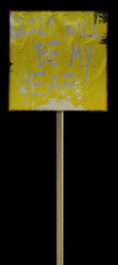 detail macro photo of selfmade paperboard protest sign with long handle isolated on black background with text saying 2021 will be my year, coronavirus meme content.