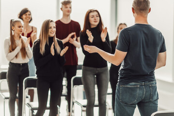 Naklejka premium speaker and a group of young people sitting in a conference room