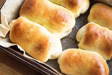 Lush, ruddy, buns in a baking tray on parchment paper close-up