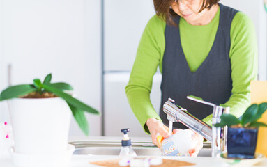 Japanese senior woman washing dishes