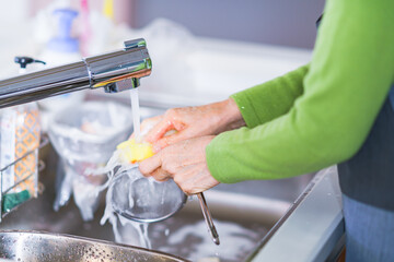Japanese senior woman washing dishes