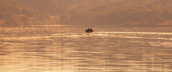Fototapeta premium Fishing boat on the lake in the morning. Banner, wide format