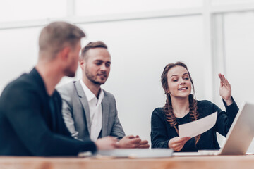 young business woman makes a report at a group meeting