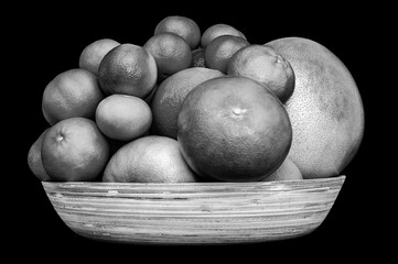 Monochrome isolated plate full of citruses fruits. Set of oranges, tangerines, limes, pummelo, grapefruits on black background.