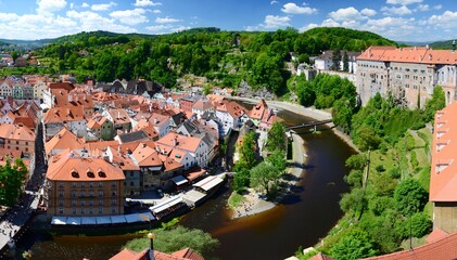 Fototapeta na wymiar Panoramic view of the historic center of Cesky Krumlov, Czech Republic. View from the castle tower, red roofs of historic houses, the Vltava river, the castle and chateau.