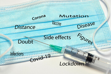 Medical blue white facemask with vaccine needle on a empty copy space background