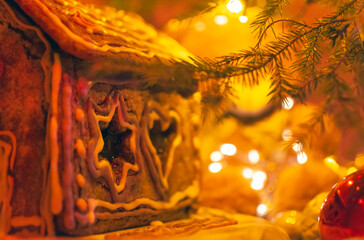 Gingerbread house under decorated Christmas tree