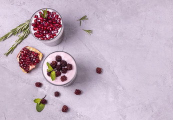 healthy smoothie with Chia seeds and blackberries and pomegranate with rosemary on a concrete...