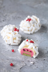 Contemporary Red Fruit and Matcha Tea Individual Mousse Cakes, decorated with Meringue Cookies, on a grey background.