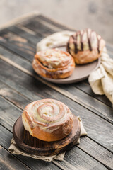 Cinnabon buns on a wooden Board with a napkin on a dark background.