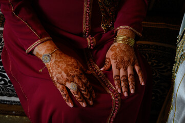 Manos de mujer con anillos y joyas diseño en con henna vestido típico indio o arabe de color rojo...