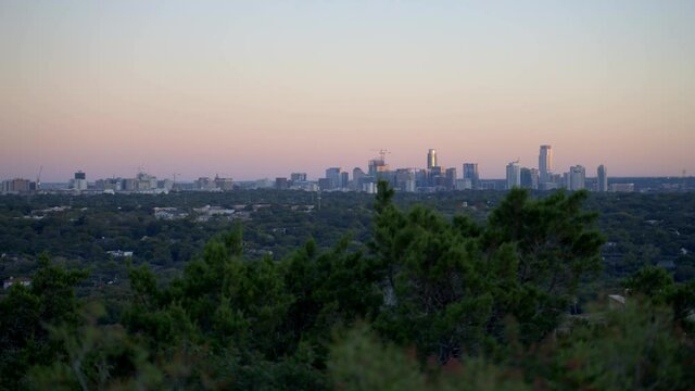 Handheld 4k slow motion establishing shot of the cityscape and buildings of Austin, Texas from public park in the warm, south American state