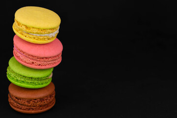Macaroons, French almond flour cookies on a black background.
Copy space.