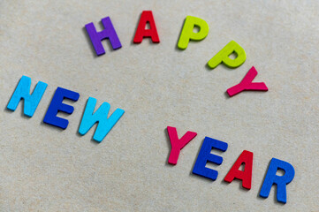 Happy new year font art colorful texting for greeting or celebrate card with light brown background, Sensitive Focus