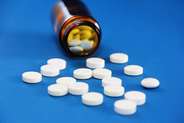 medicinal pills and a glass bottle on a blue background