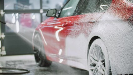 Auto detailing - covering the car with a cleaning foam