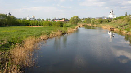 Fototapeta na wymiar View of the Kamenka river and the domes of the Alexander and Pokrovsky monastery in Suzdal