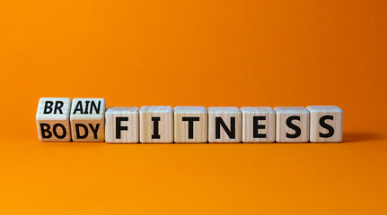 Train your brain. Turned a cube and changed words 'body fitness' to 'brain fitness' on wooden cubes. Beautiful orange background, copy space. Business and train your brain concept.