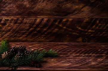Christmas cones and branches on wooden boards. - 401246820