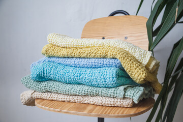 Towels of different colors from natural linen and cotton fabrics are on a pile on a chair