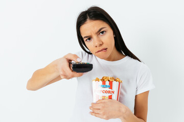 Young woman with remote control and popcorn