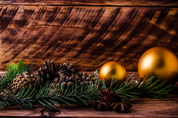 cones and branches on wooden boards with a large Christmas ball. - 401249043