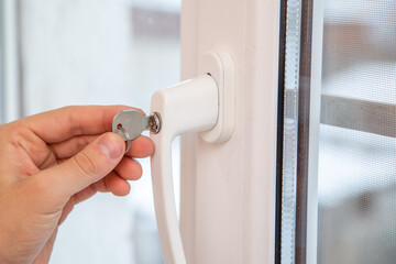 hand with a key closes the window