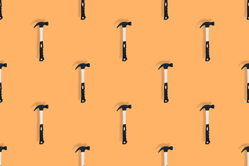 Hammer on an orange background. Hammer seamless pattern.