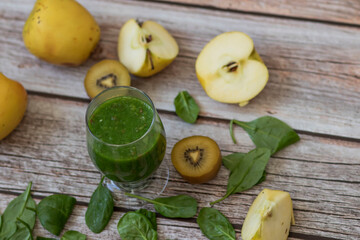 
A glass of kiwi, spinach and apple smoothie. Health drink. Apples, flax seeds, spinach, kiwi, bananas lie nearby.