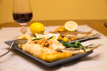 close up of dishes with golden fried fish and wine