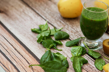 
A glass of kiwi, spinach and apple smoothie. Health drink. Apples, flax seeds, spinach, kiwi, bananas lie nearby.