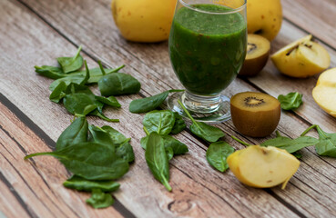 
A glass of kiwi, spinach and apple smoothie. Health drink. Apples, flax seeds, spinach, kiwi, bananas lie nearby.