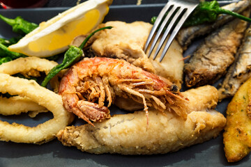 close up of dishes with golden fried fish and wine