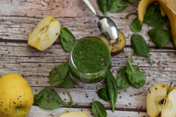 
A glass of kiwi, spinach and apple smoothie. Health drink. Apples, flax seeds, spinach, kiwi, bananas lie nearby.