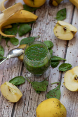 
A glass of kiwi, spinach and apple smoothie. Health drink. Apples, flax seeds, spinach, kiwi, bananas lie nearby.