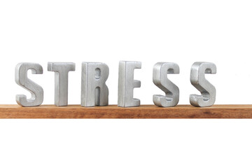Ein Holzbrett mit dekorativen Buchstaben die das Wort Stress bilden