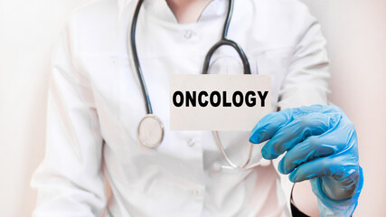 The doctor's blue - gloved hands show the word ONCOLOGY - . a gloved hand on a white background. Medical concept. the medicine