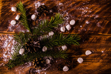 Obraz na płótnie Canvas Christmas cones and branches on wooden marshmallow boards
