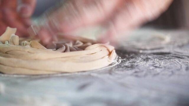 Man is preparing dough noodles