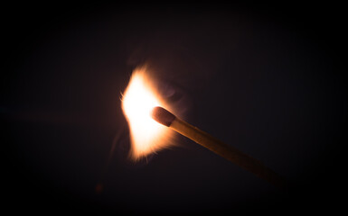 Fire burning on matchstick. Isolated on black background.