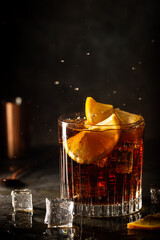 Fresh made Cuba Libre cocktail with brown rum, cola and lemon on wooden background