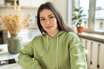 Leisure, free time and electronic devices. Indoor image of young brunette female in stylish hoodie...
