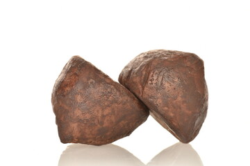 Two delicious chocolate truffles, close-up, on a white background.