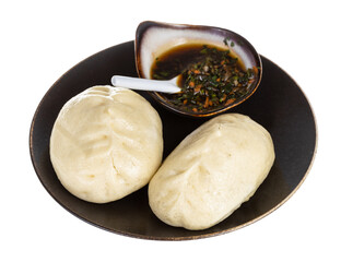 Wang Mandu Pyanse (steamed pie stuffed with vegetable and meat in Korean cuisine) on brown plate served with sauce isolated on white background