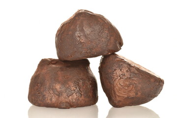 Three delicious chocolate truffles, close-up, isolated on white.