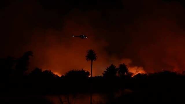 People watch massive fire burning at river bottom in Ventura, CA.