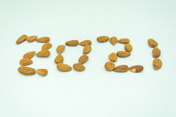 Raw dry almonds with white background arranged as numerical 2021 signifying coming year