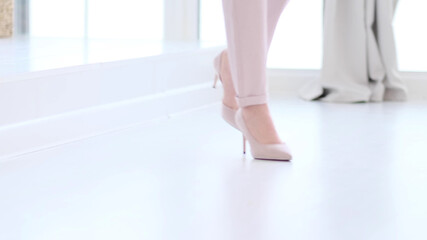 Fashionable woman wearing high heel shoes. Fashionable woman in high-heeled shoes. soft focus woman walking on white wooden floor.