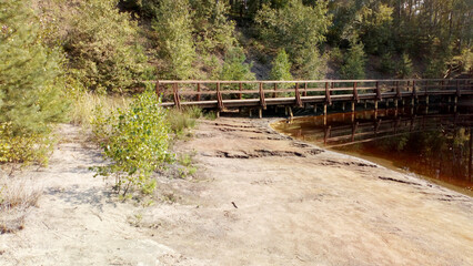 Drewniany mostek nad zbiornikiem wodnym.