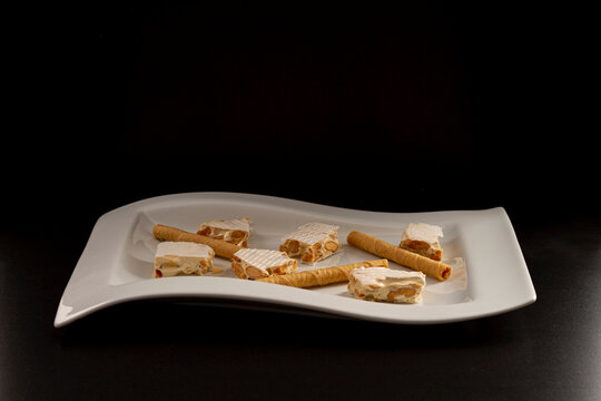 Assortment of Spanish Christmas sweets made up of Alicante nougat and wafer canutillos.